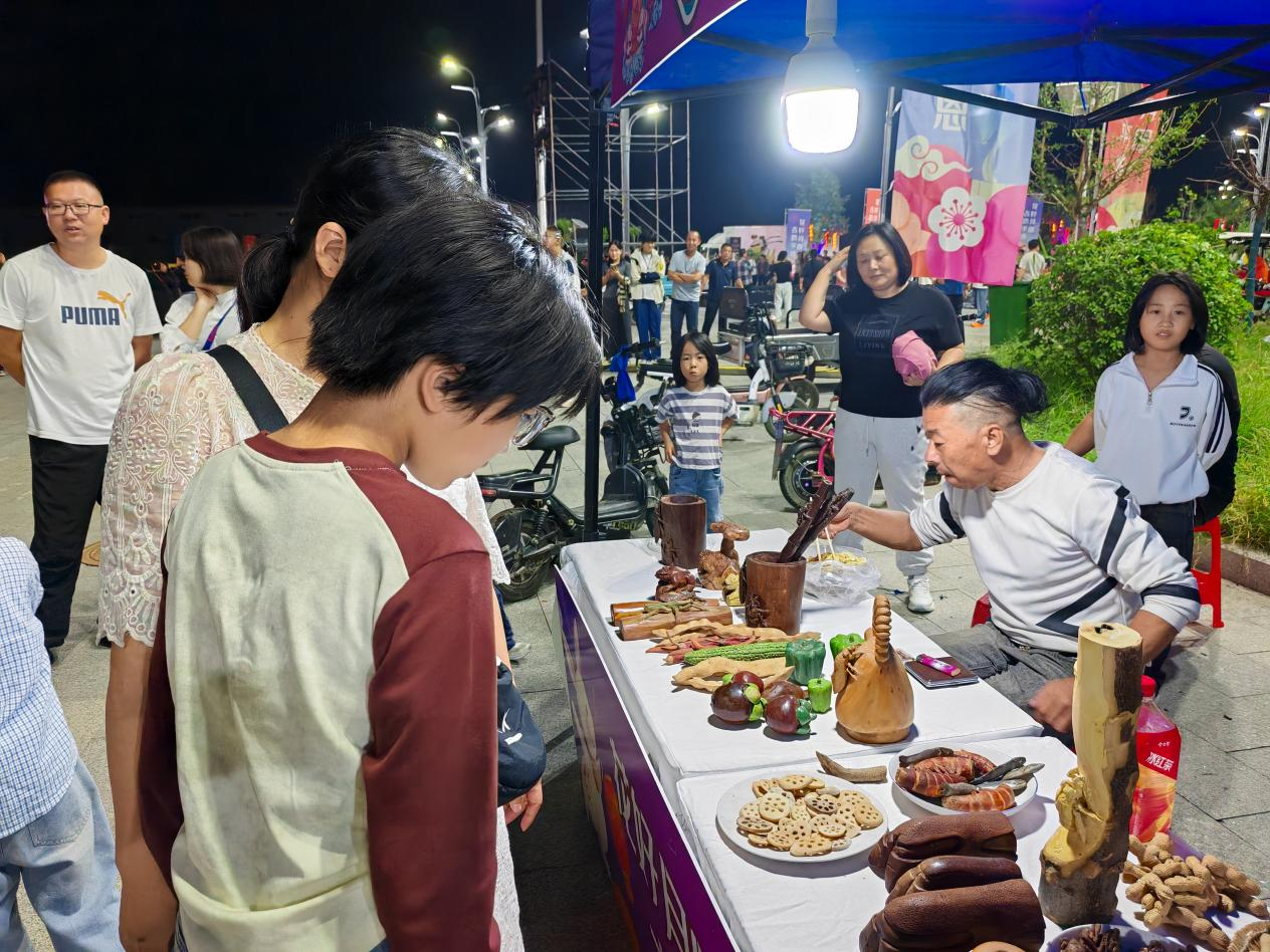 邱縣在鯤鵬國際會展中心廣場舉辦優選市集，非遺“根雕”攤位前吸引了眾多游客。李文娟攝