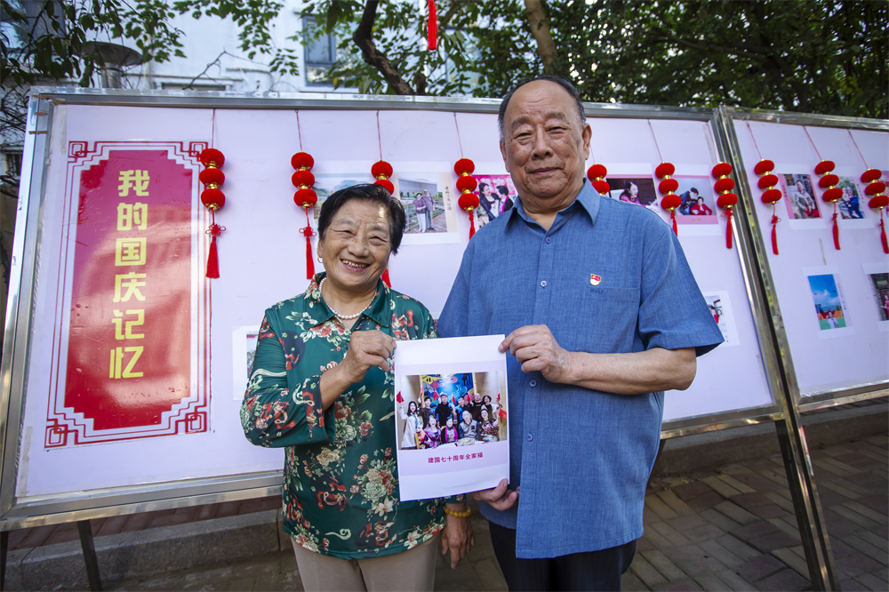 9月24日，河北省邯郸市复兴区化林路街道建西一社区，退休干部赵鸿皎（右）、和秀英（左）夫妇手举庆祝新中国成立70周年时拍摄的全家福。聂长青摄