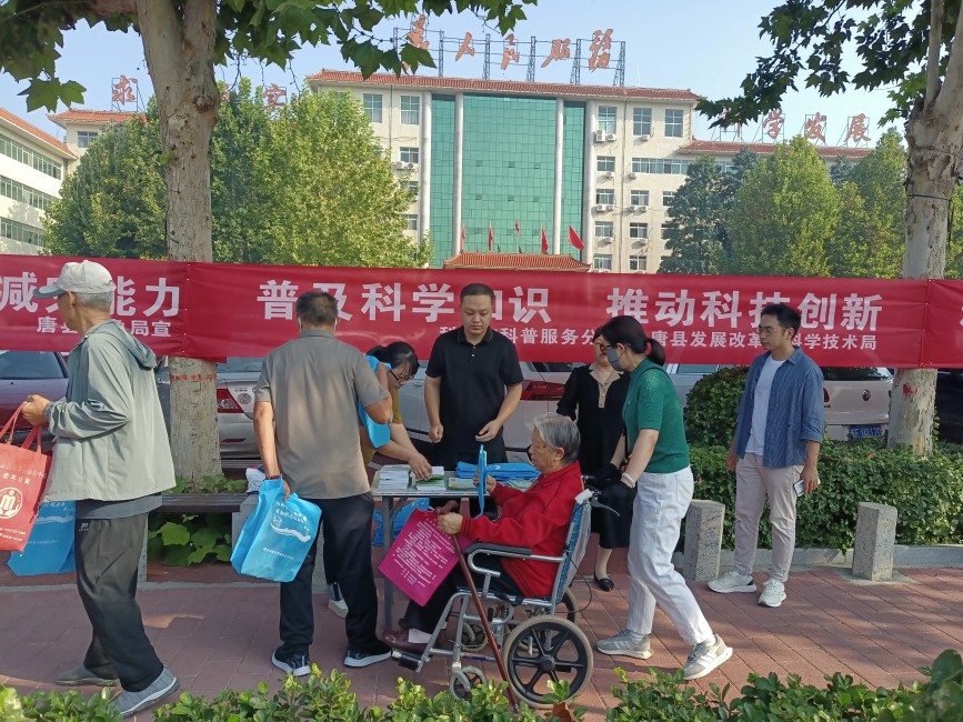 工作人员向过往群众发放宣传手册。任可摄