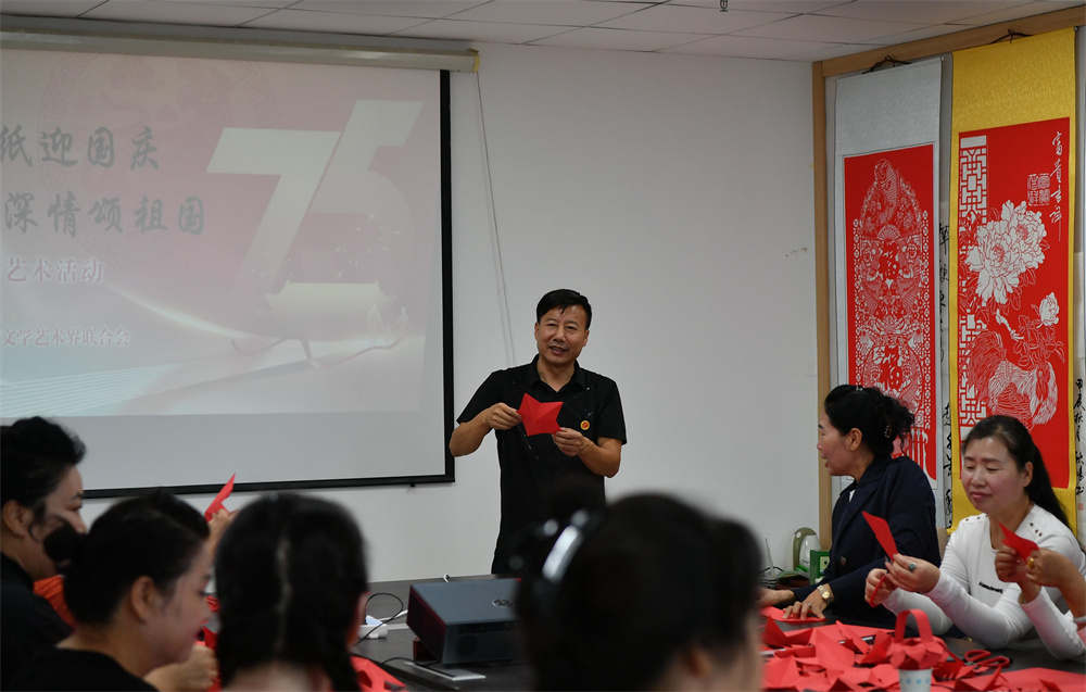 9月27日，非遗传承人张文芳正在现场教授大家剪纸。邹雅婕摄
