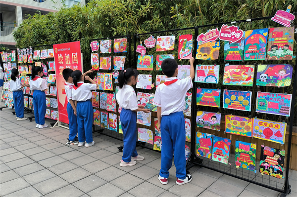 9月29日,在河北省保定市实验小学,学生们欣赏国庆节主题手抄报。王雅璇摄