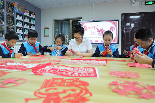 9月29日,在河北省保定市新市场小学,师生一起创作国庆节主题剪纸。孙雨祺摄