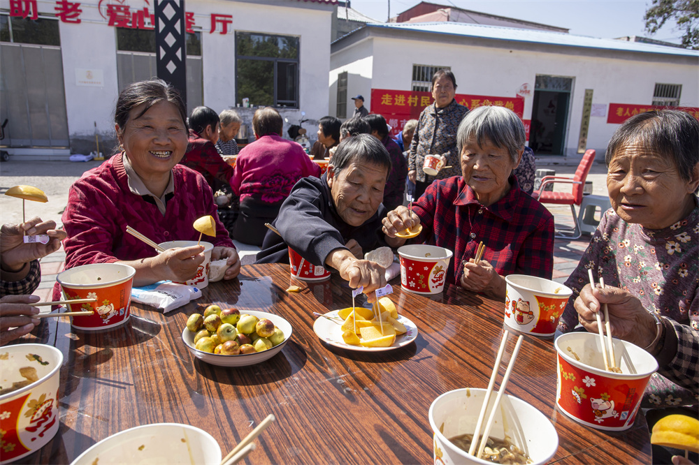 10月1日，河北省邯郸市复兴区户村镇户村村，老年人在品尝水果。聂长青摄