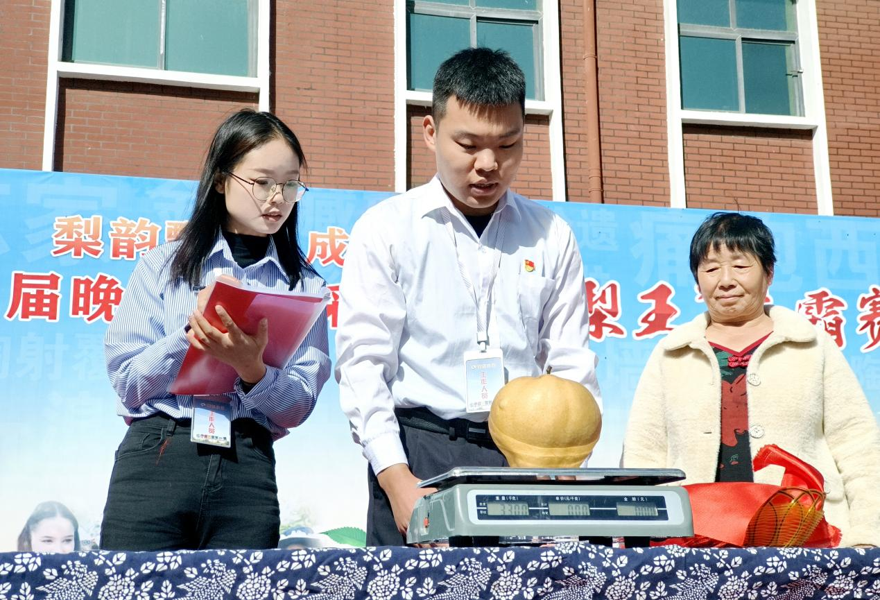 评委正在对参赛梨农的参赛果品进行称重。郝立翠摄