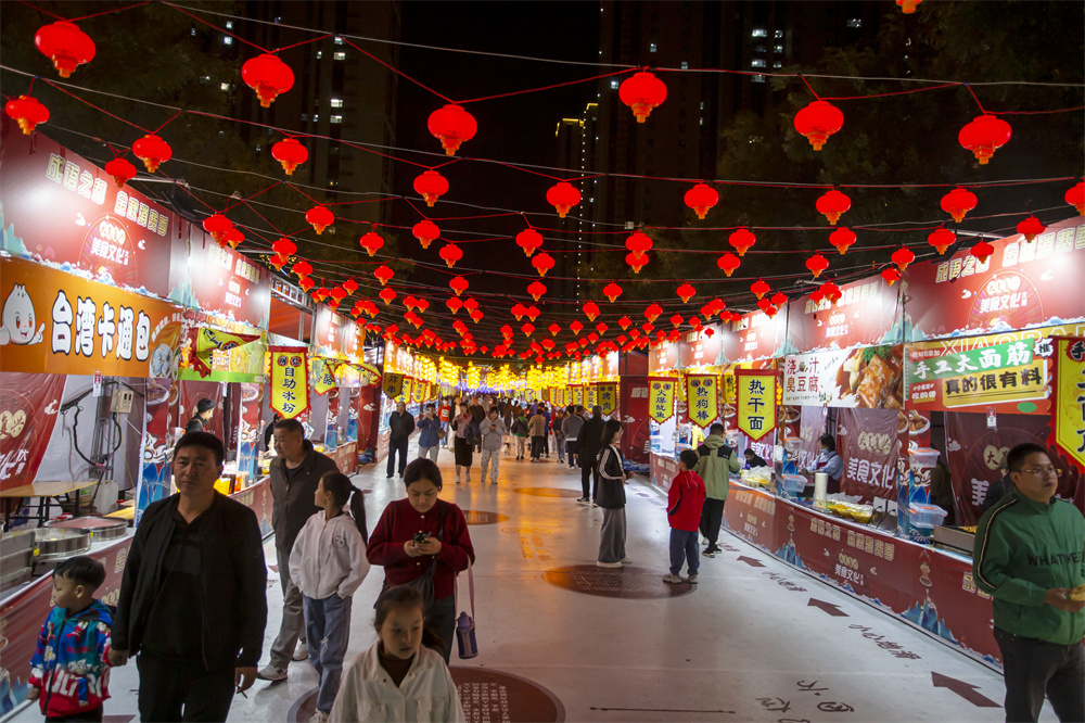 10月2日晚，河北省邯郸市复兴区银泰时光街，游客在逛小吃一条街夜市。聂长青摄