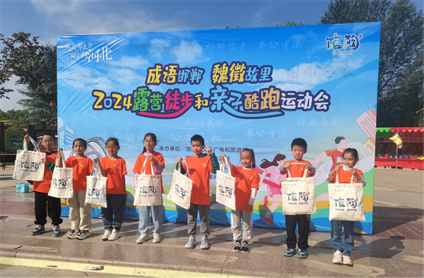 馆陶县2024露营徒步和亲子酷跑运动会上,为参与挑战的小朋友送文创包。馆陶县委宣传部供图
