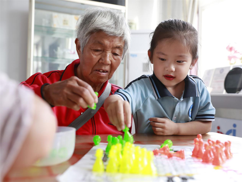 孩子和老人们一起下跳棋、玩游戏。杨晨摄