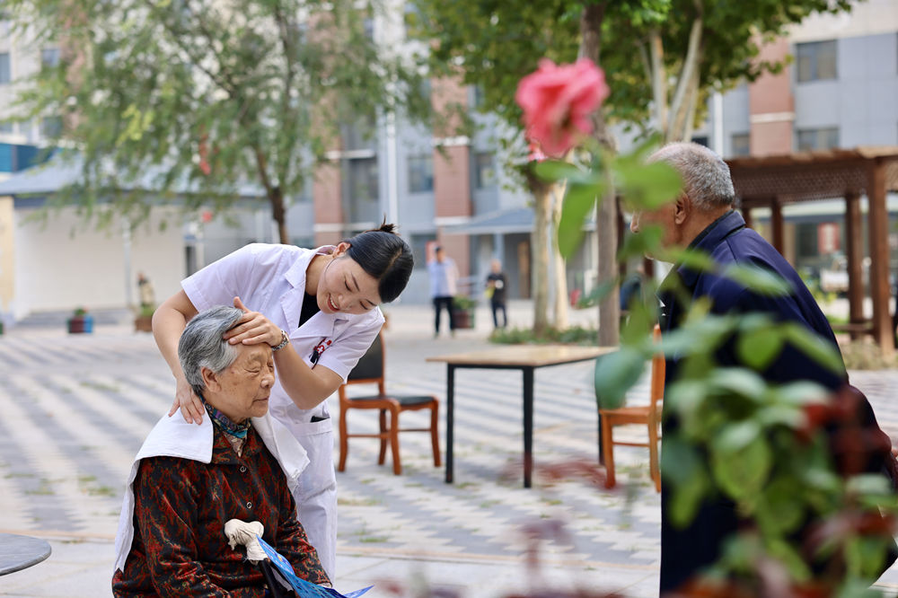 志願者為老人進行按摩理療。鄧博攝