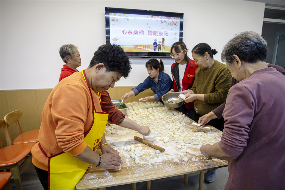居民在社区食堂帮忙包饺子。聂长青摄