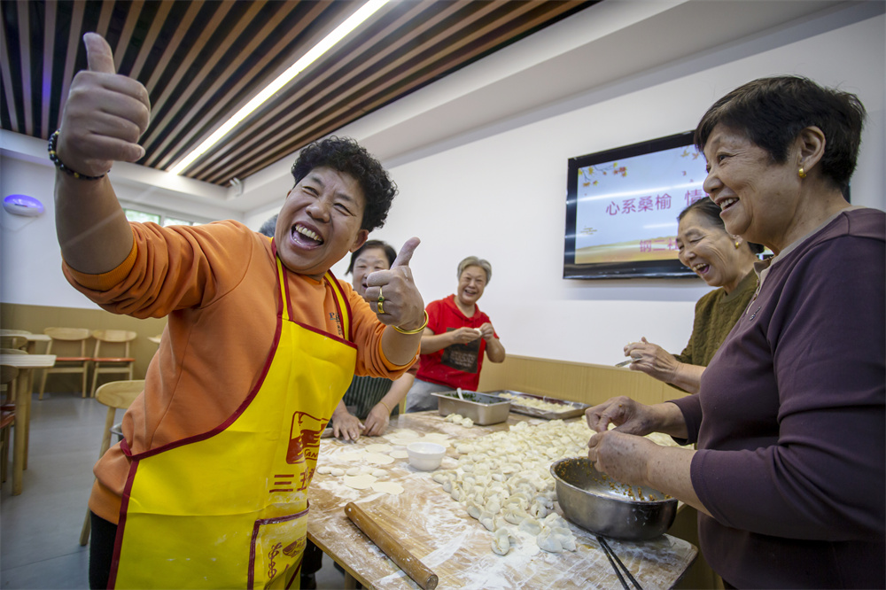 居民在社区食堂帮忙包饺子。聂长青摄