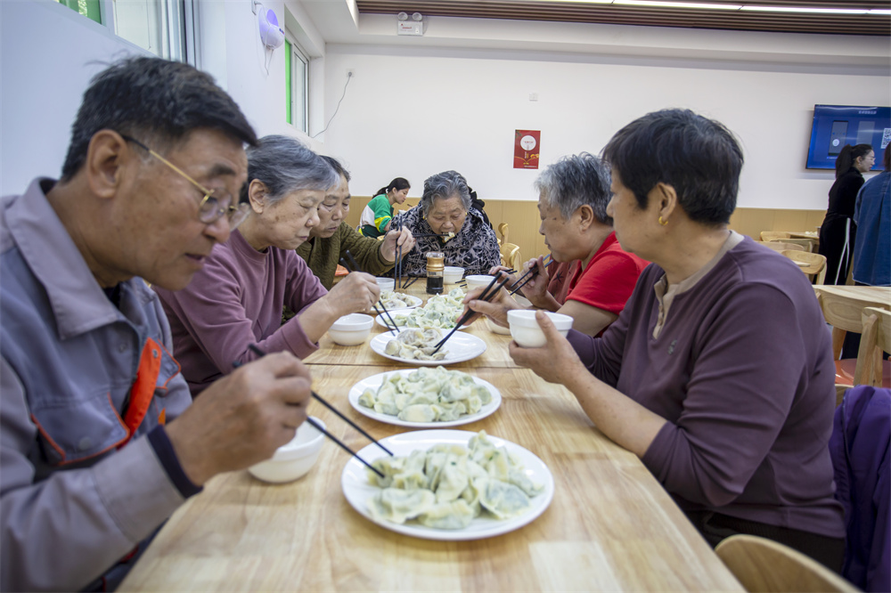 居民在社区食堂吃饺子。聂长青摄