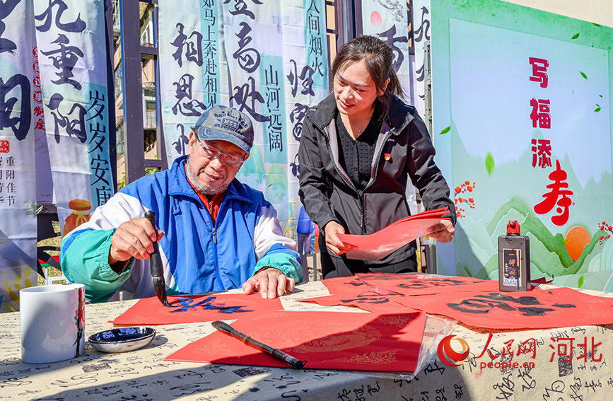 “寫福添壽”書法活動向老人送祝福。人民網記者 周博攝