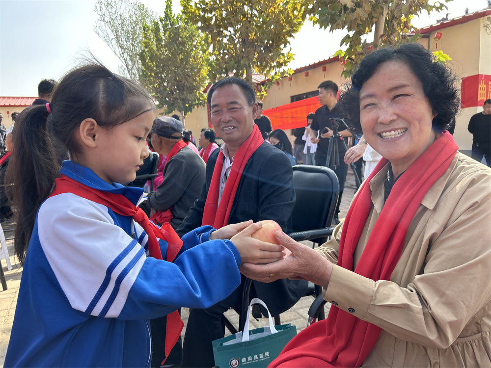 小朋友為老人送上蘋果和祝福。玉婷攝