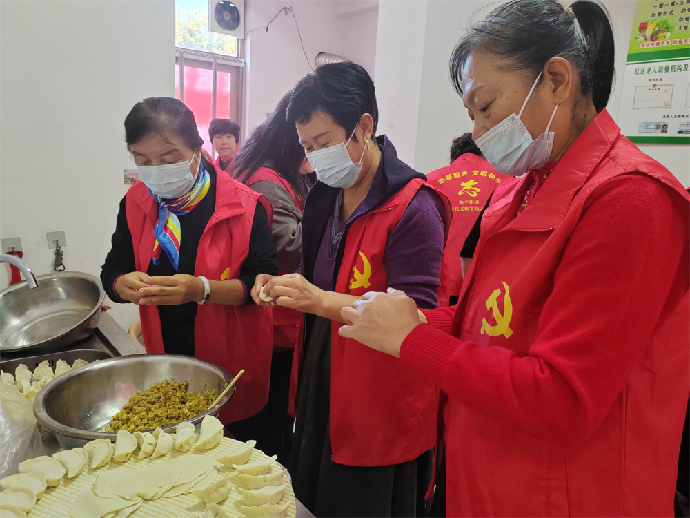 10月10日，在河北省高碑店市和平街道乾荣社区党群服务中心，辖区志愿者为老人们包饺子。米彤摄