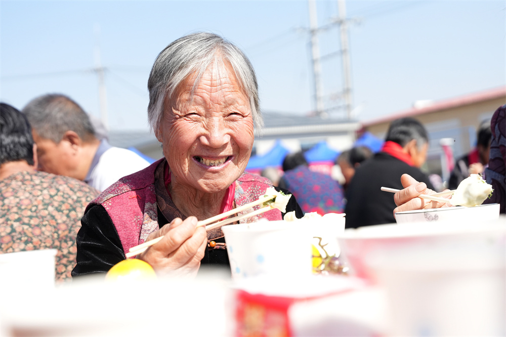 10月11日,在隆堯縣隆堯鎮堯北裡村首屆餃子宴,老人正在吃著香噴噴的餃子。王雪攝