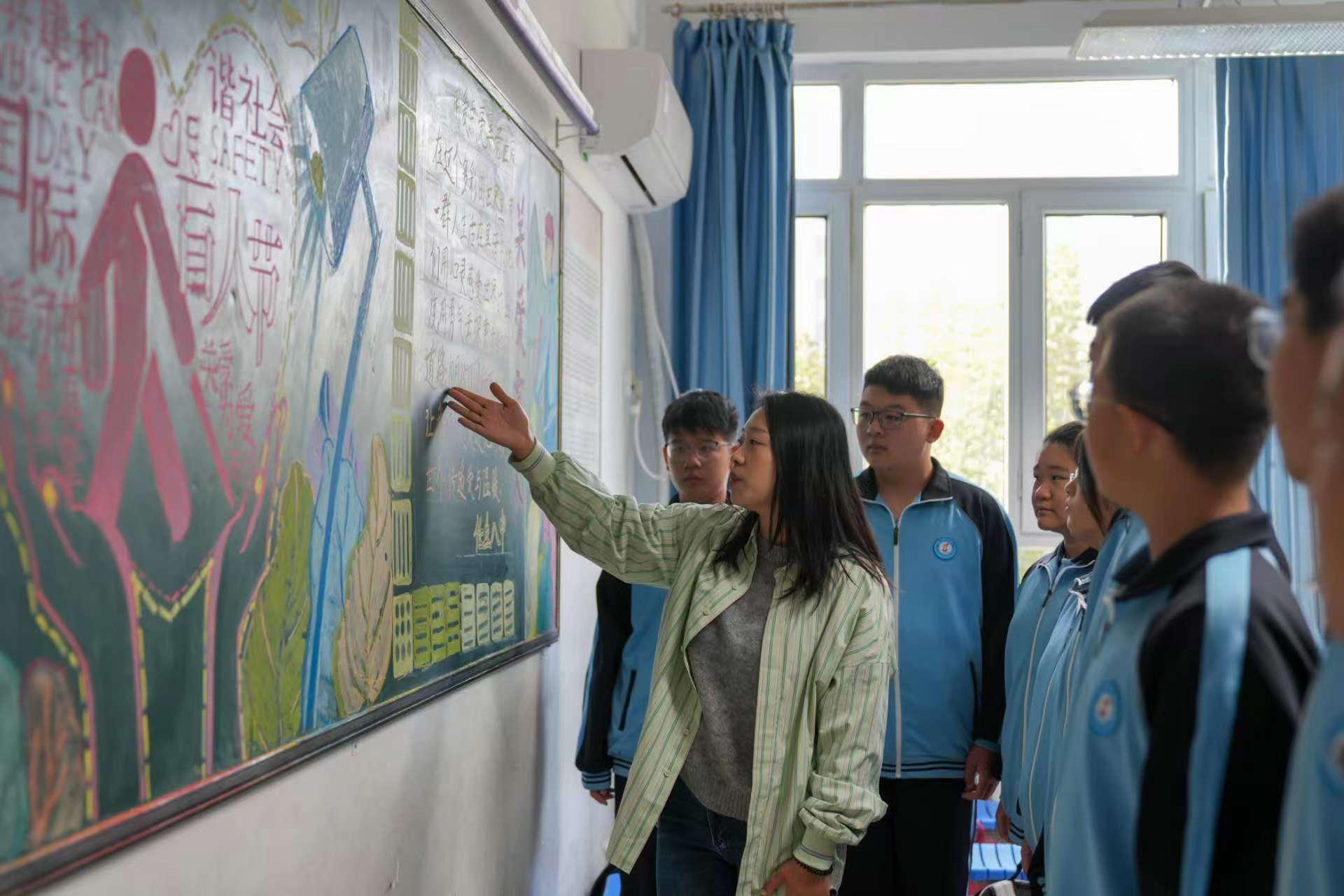 任丘市第八中学老师为学生讲解“国际盲人节”相关知识。韩慧峰摄
