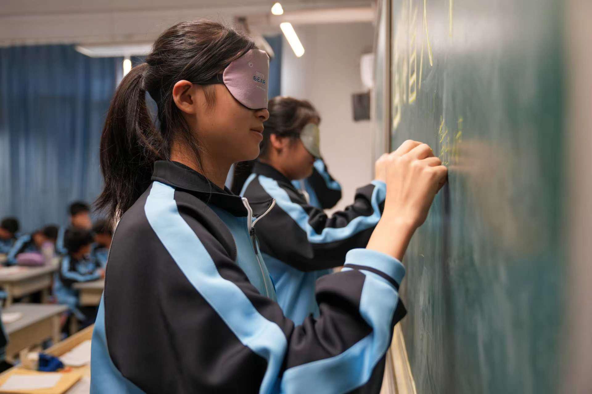 任丘市第八中学学生戴着眼罩在黑板上默写古诗。韩慧峰摄