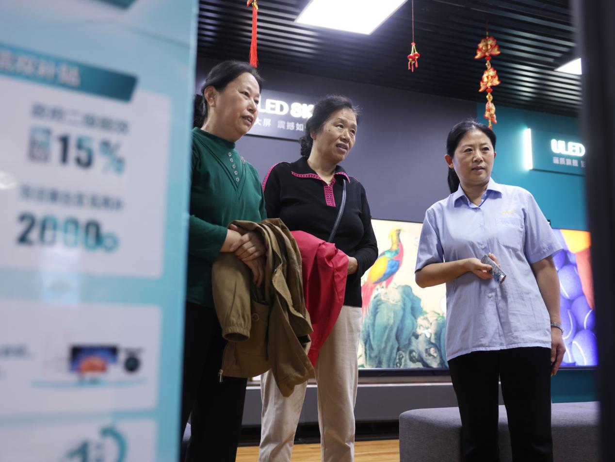 销售人员介绍家电以旧换新优惠政策。杨晨摄