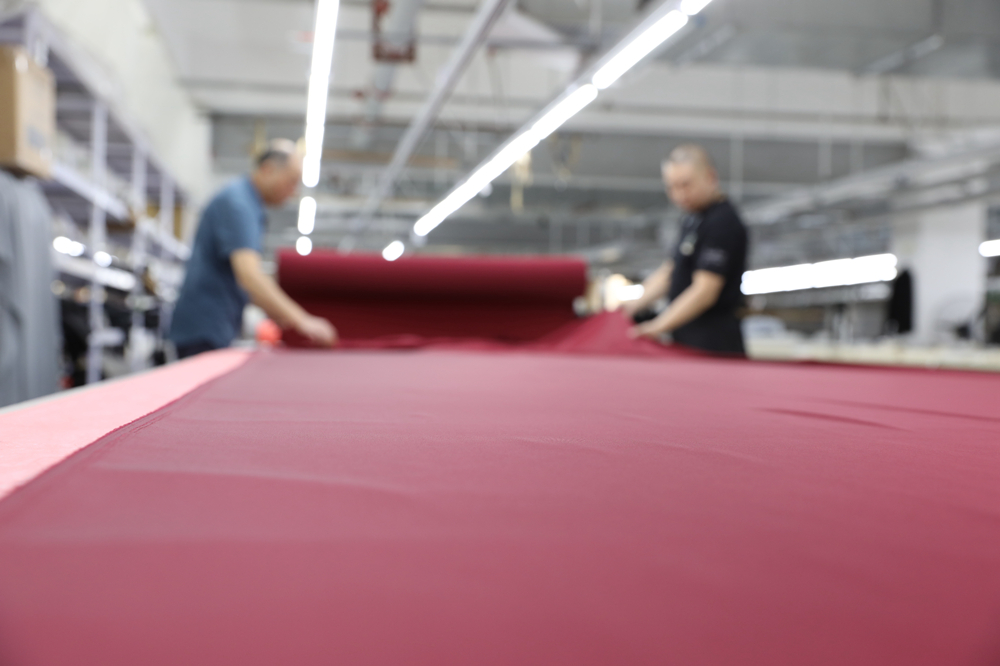 工人在京津轉移服裝企業裁剪車間工作。田博攝