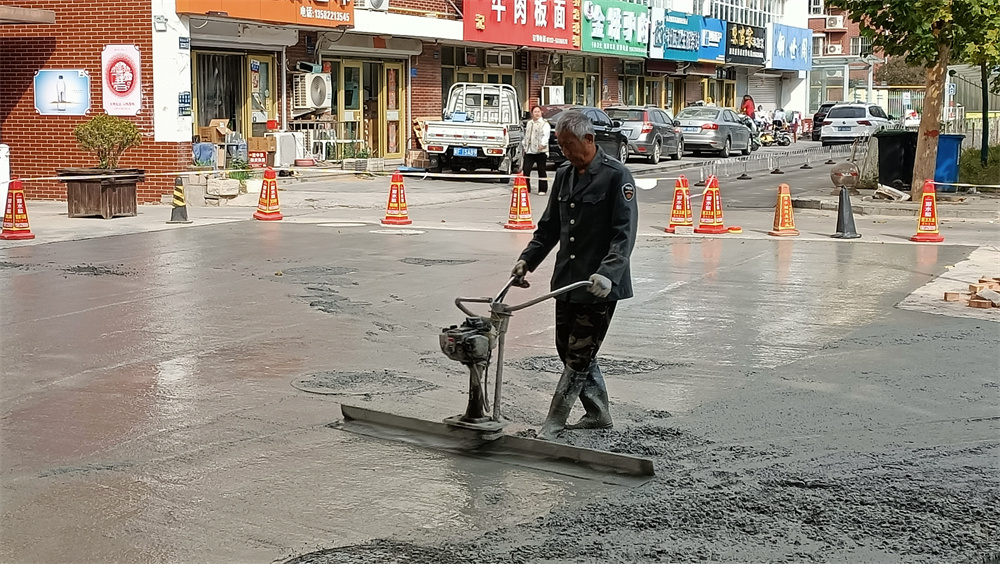 工人正在用振尺为路面找平。孙悦摄