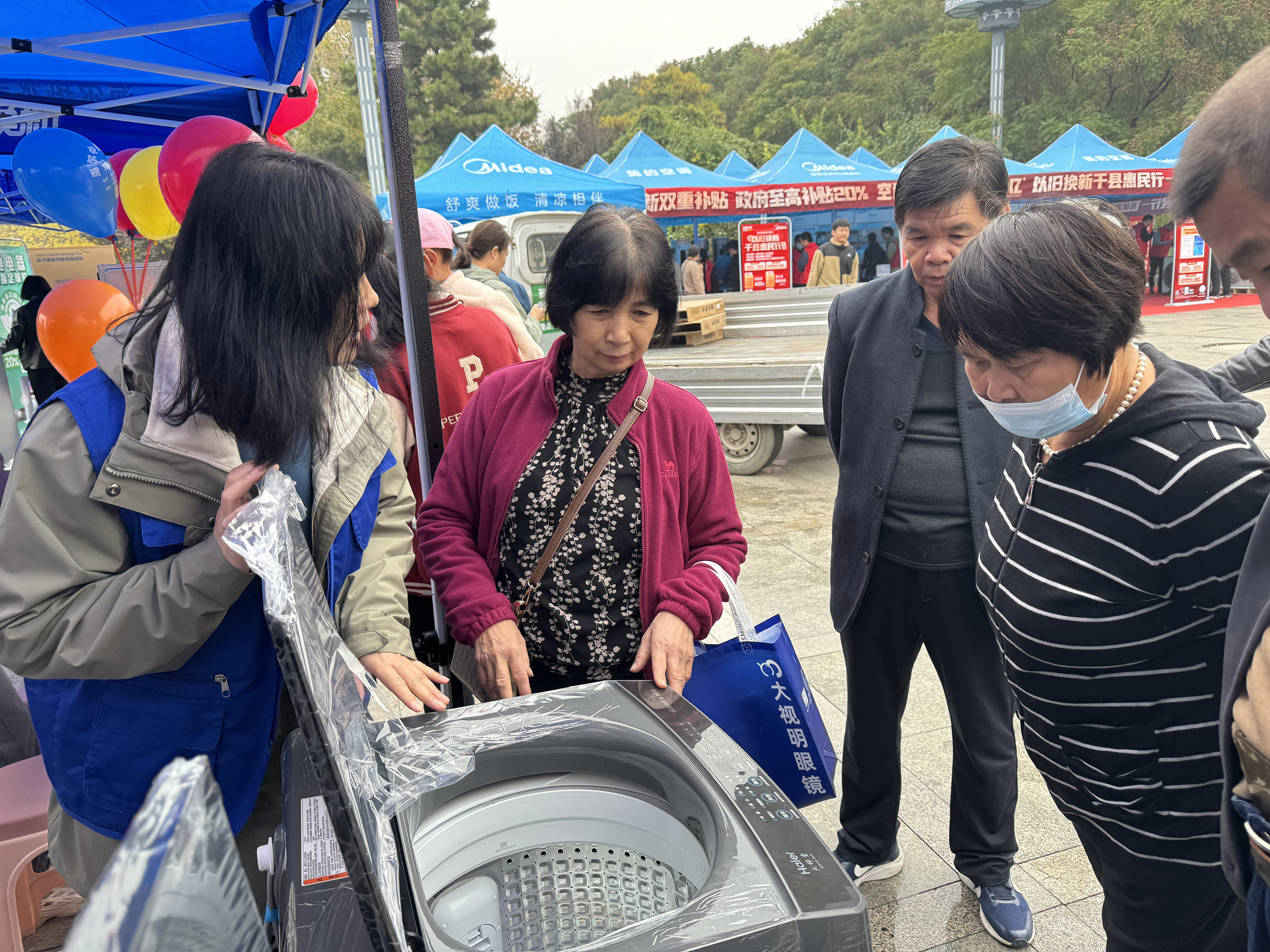 在活动现场，工作人员为群众耐心讲解国补政策和产品性能。王娟摄