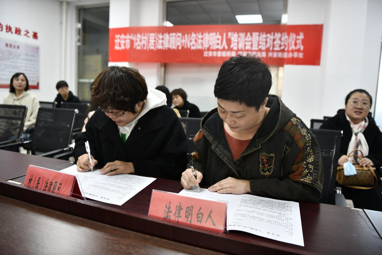 法律顾问杨立芳和法律明白人签订了《村(居)法律顾问与“法律明白人”结对协议》。梁玉水摄
