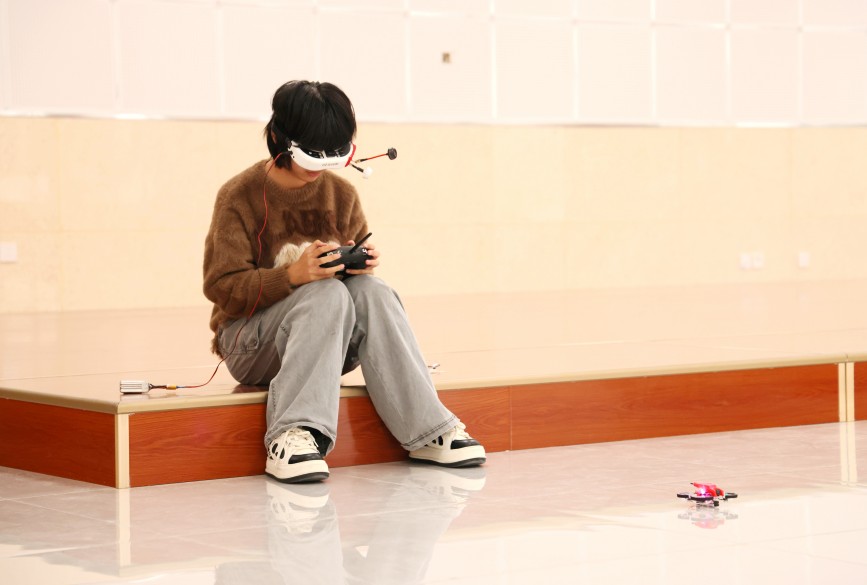 多轴无人机竞速项目中，参赛选手正在遥控操作无人机。王杰摄