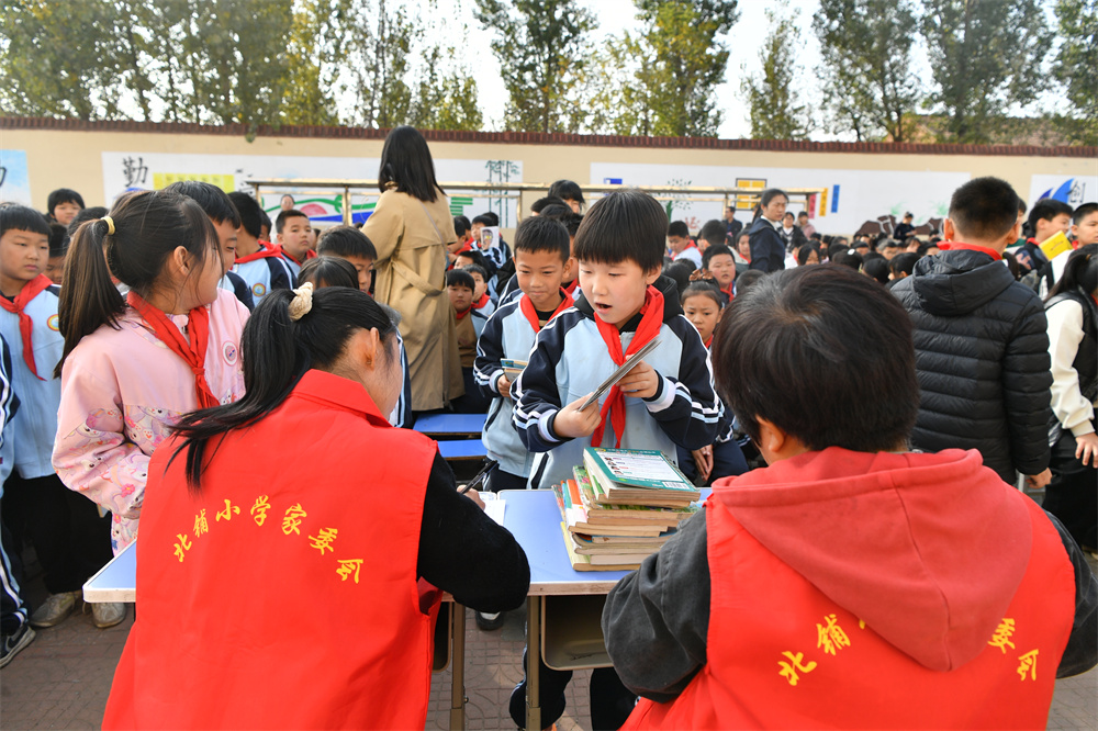 10月30日，迁安市沙河驿镇北铺完全小学学生们正在向学校捐赠图书。张泽慧摄