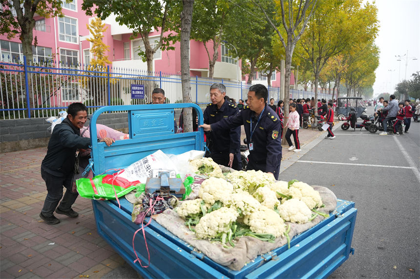 10月31日，在隆堯縣第二實驗小學，城管局工作人員正在對校外流動攤販進行綜合治理。王鑠攝