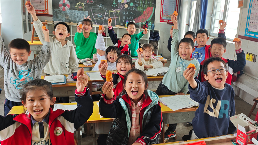 肃宁县师素镇东谈完小学生们展示自己制作的烤红薯。孙雅潇摄