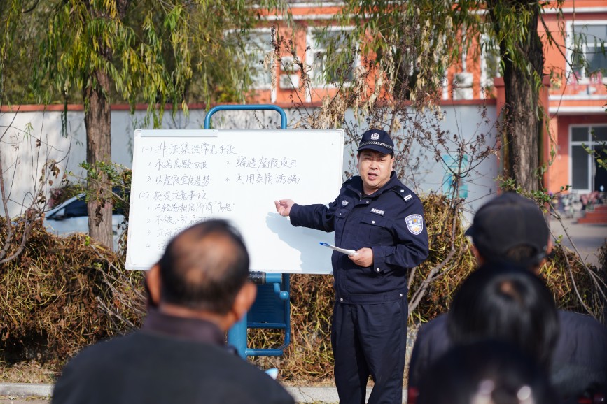 迁安市上庄镇派出所民警为平林镇村的村民讲解防范非法集资知识。李海欣摄