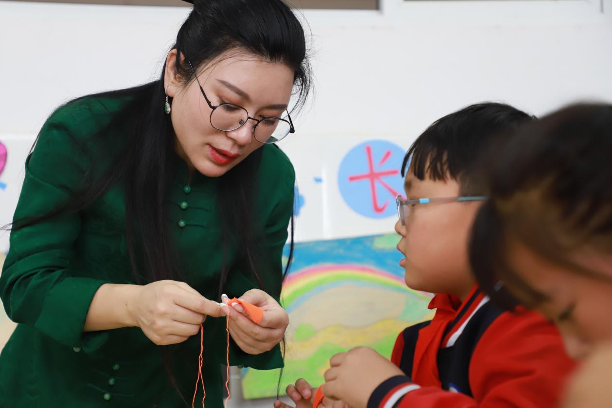 李钰淇教孩子们学习手绣的基本针法。杨洋摄 