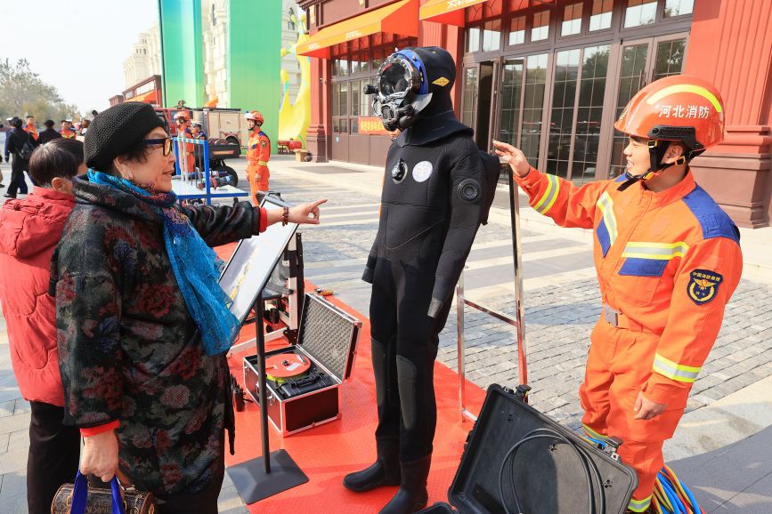 装备器材展示区，工作人员介绍消防设备使用与功能知识。吴宇涛摄