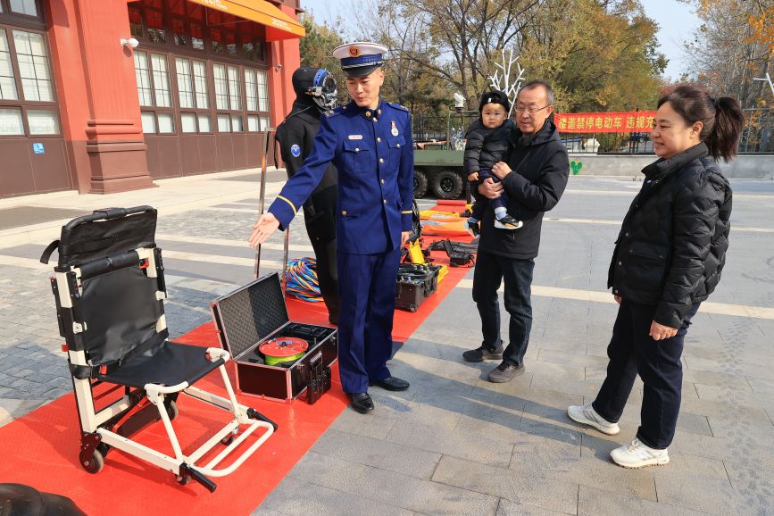 装备器材展示区，工作人员介绍消防设备使用与功能知识。吴宇涛摄