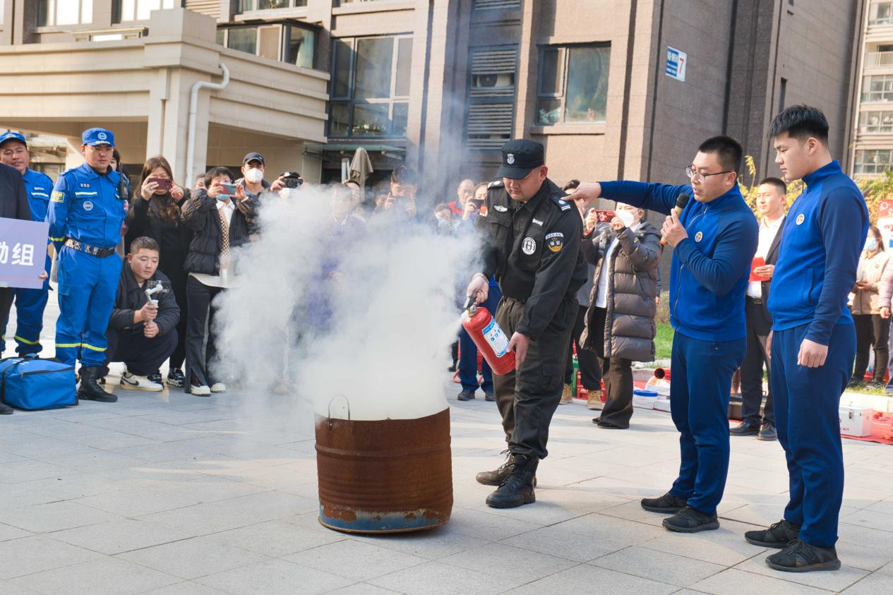丰南区消防救援大队的消防人员向居民讲解日常火灾灭火方法。毕帅摄