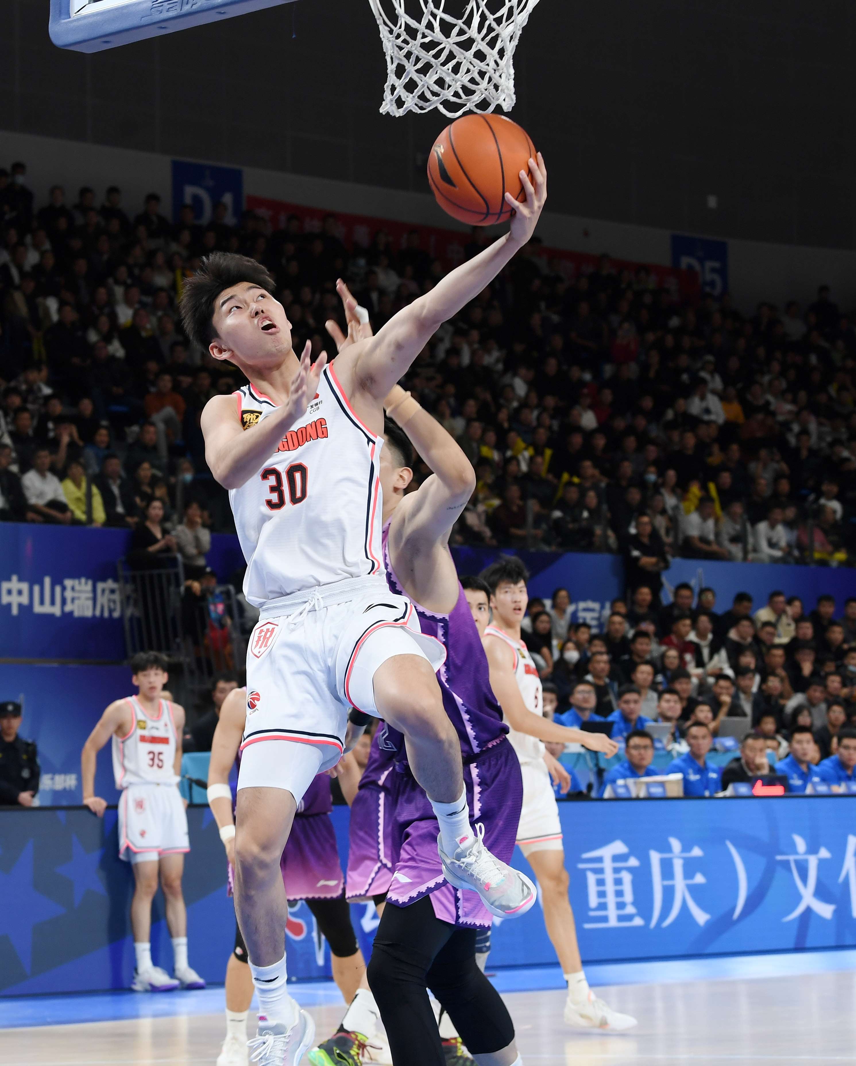 广东东阳光球员李奕臻（前）在比赛中上篮。白永民摄