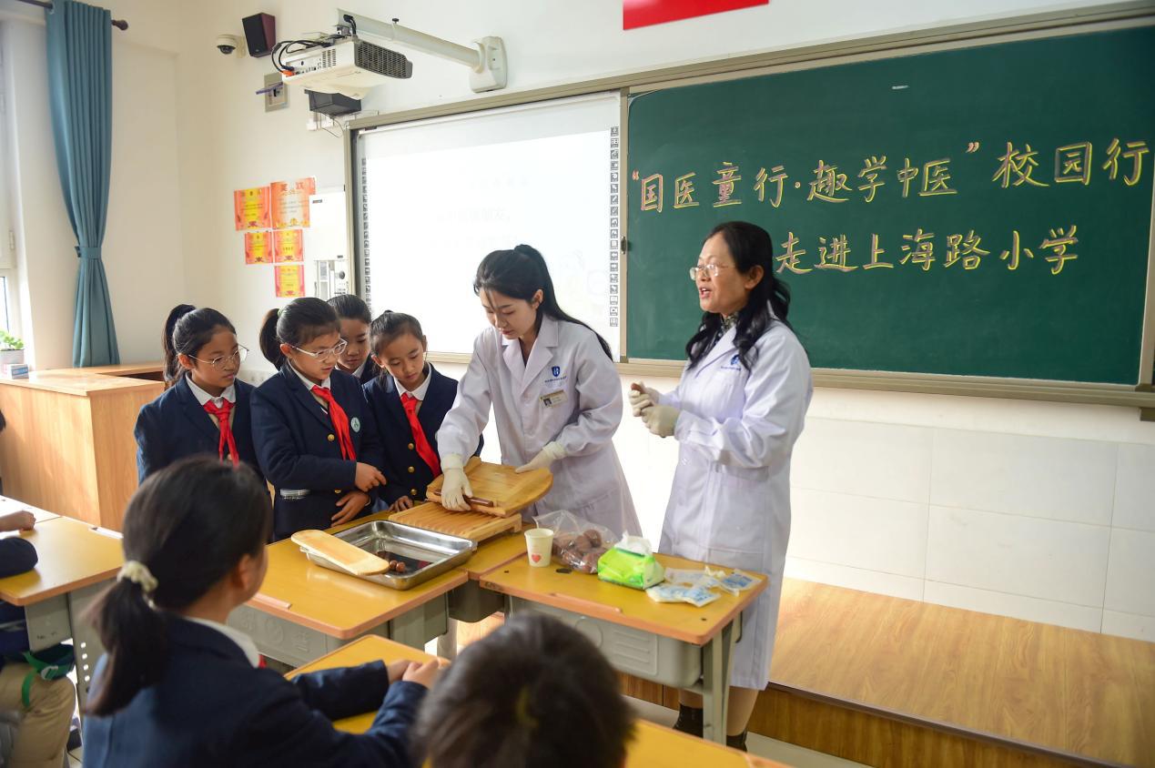 河北省沧州中西医结合医院的中药师在上海路小学现场演示制作中药丸。邓小燕摄