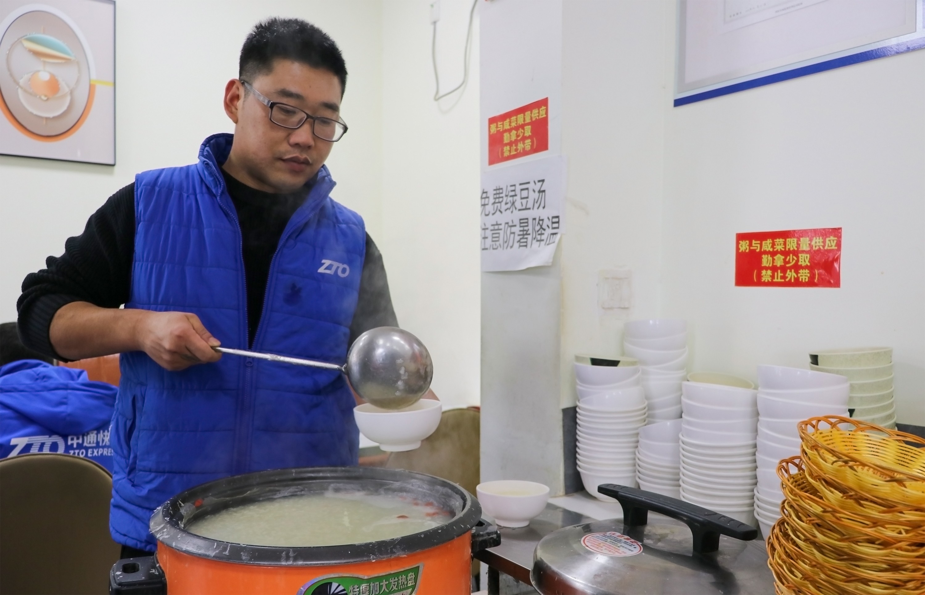 11月22日,快递小哥享用食堂免费供应的米粥。杨少杰摄