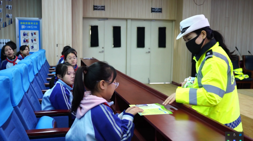 迁安市公安交警大队的宣传员在迁安市第八实验小学给学生发放安全宣传单。唐珺摄