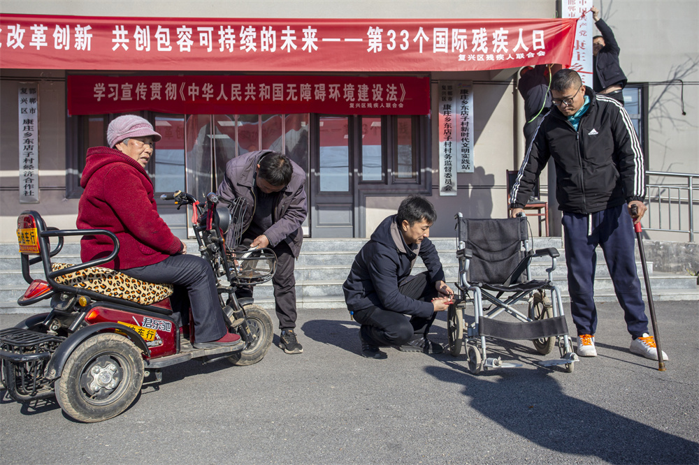 12月3日，河北省邯郸市复兴区残联在康庄乡东店子村举办“携手同行，让爱无碍”2024年国际残疾日主题活动。这是为残障人士维修轮椅。聂长青摄