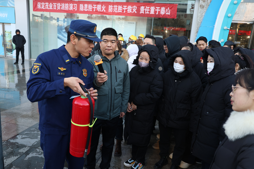 消防员讲解灭火器使用方法。梁佳琛摄