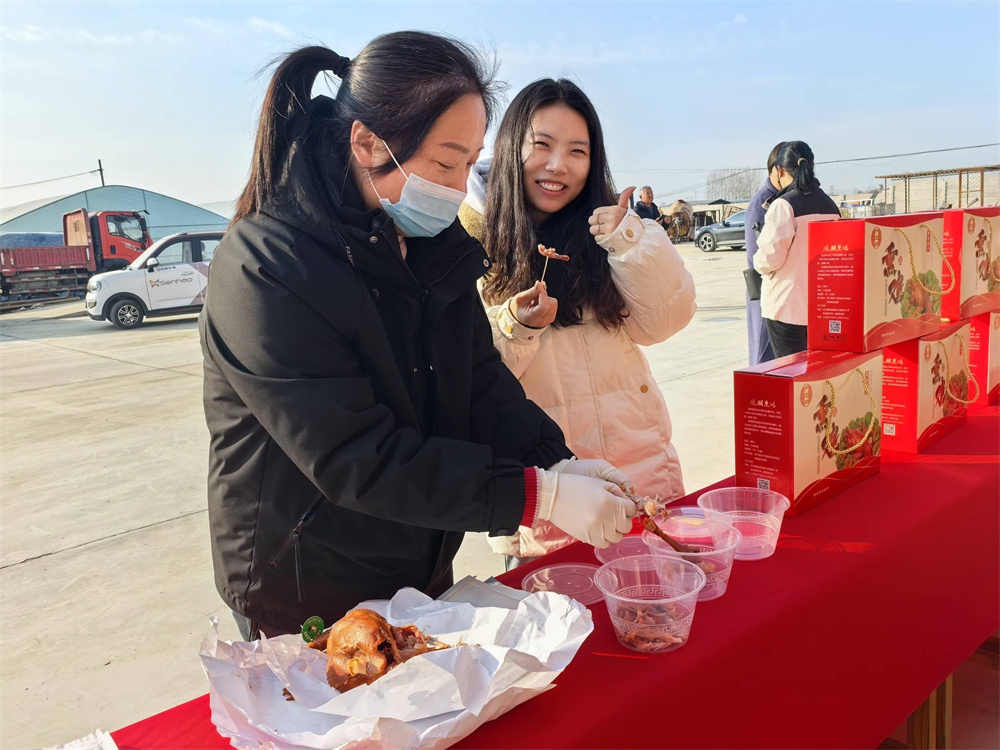 12月8日，游客在隆堯縣東良鎮黃營村土特產品展示會現場試吃本地的魏庄熏雞。楊秋芳攝