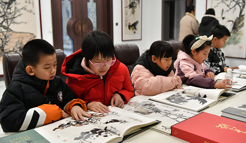 12月22日，孩子们正在迁安市李涵美术馆参观画册。张泽慧摄