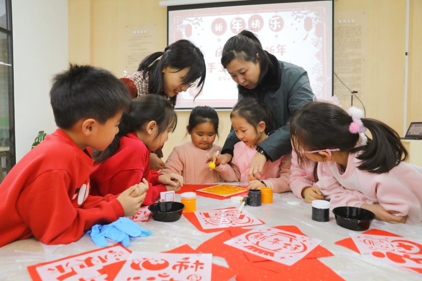 12月30日，在保定市竞秀区青年新城社区，亲子一起拓印福字。母东莹摄