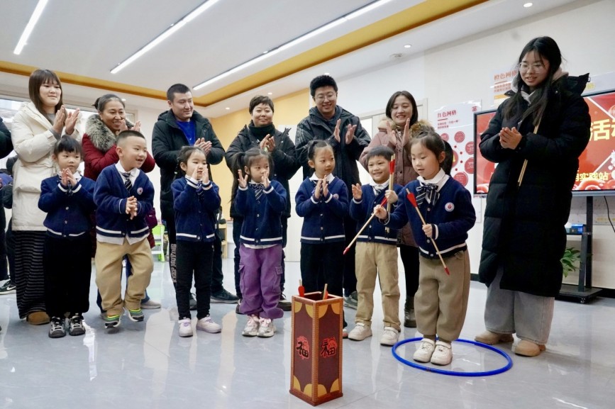 12月30日，在保定市竞秀区先锋街道华南社区，小朋友和家长一起投壶。石璐琪摄