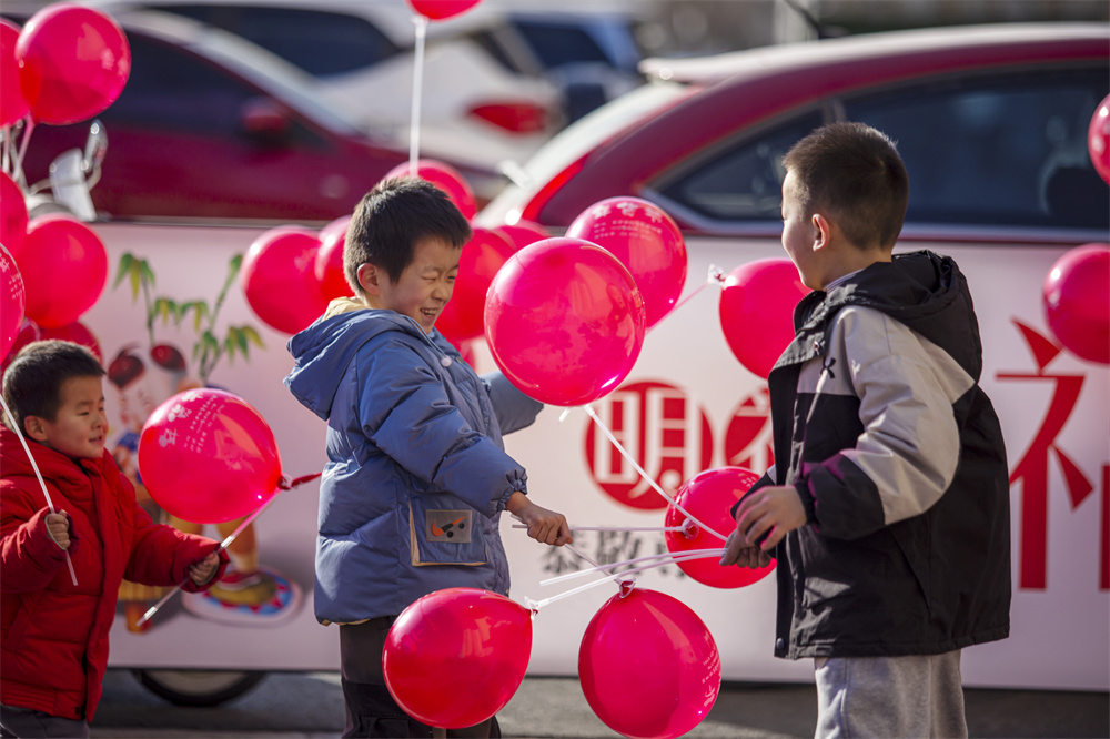 1月8日，河北省邯鄲市復興區百家村街道鋼一社區百二小區門前，由百家村街道精心組織的“年貨節”開幕了，居民在購買年貨，孩子們則在一旁玩氣球。聶長青攝