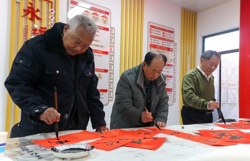 1月10日,在保定竞秀区康欣园南社区,书法艺术家为居民创作春联和“福”字。耿培轩摄