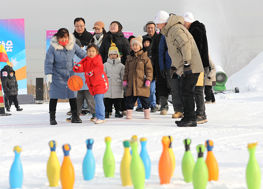 1月10日，小朋友与家长在参与雪地保龄球趣味活动。田博摄