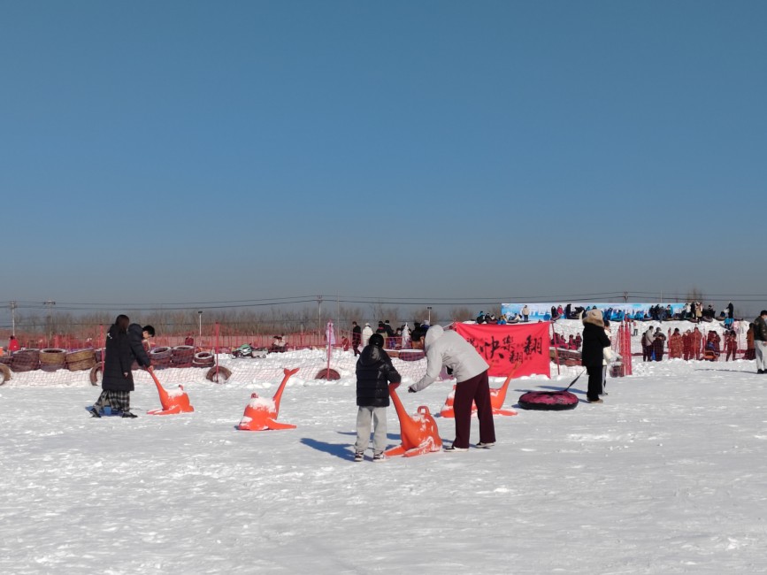 1月12日，河北省高碑店市国家登山训练基地的京南体育小镇滑雪场上，家长与孩子在雪地上嬉戏玩耍。朱珊珊摄
