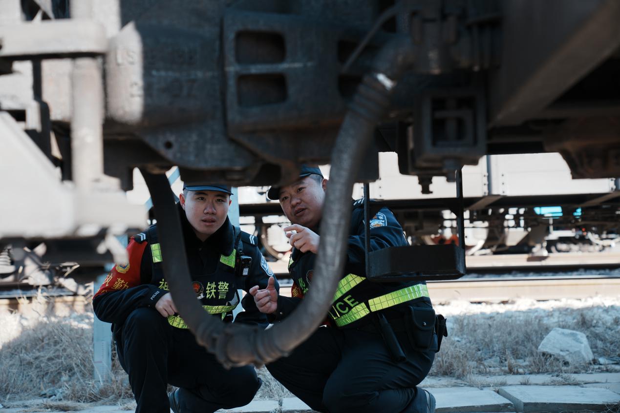 民警石李元跟着师傅纪凯查看停靠的火车。孙镁英